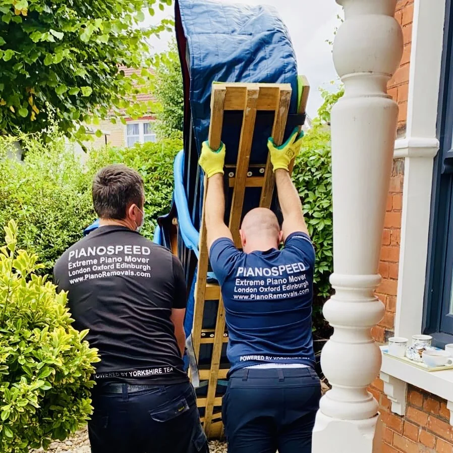 Specialist crew loading a piano for collection into storage
